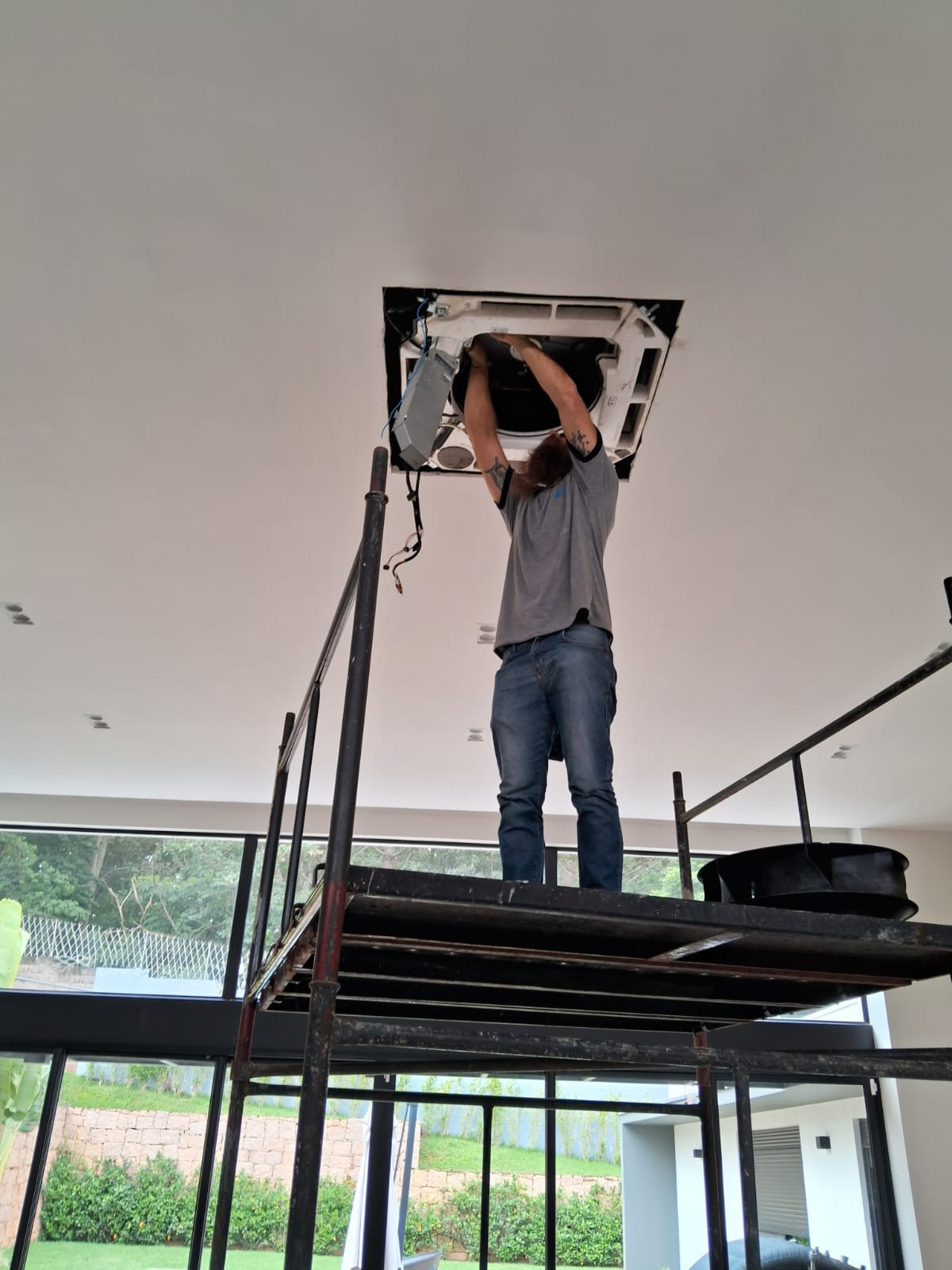 Técnico realizando instalação de ar-condicionado cassete